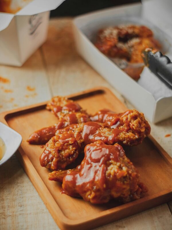 Tantalizing image of saucy fried chicken wings, perfect for food blogs and culinary enthusiasts.